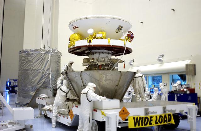 NASA image: KENNEDY SPACE CENTER, FLA. - Workers in the Payload Hazardous Servicing Facility secure the lower sections of the transport canister around the Mars Exploration Rover 2 (MER-2).  The upper portion waits at left.  After encapsulation, MER-2 will be transferred to Launch Complex 17-A, Cape Canaveral Air Force Station.  MER-2 is one of NASA's twin Mars Exploration Rovers designed to study the history of water on Mars. These robotic geologists are equipped with a robotic arm, a drilling tool, three spectrometers, and four pairs of cameras that allow them to have a human-like, 3D view of the terrain. Each rover could travel as far as 100 meters in one day to act as Mars scientists' eyes and hands, exploring an environment where humans can't yet go.  MER-2 is scheduled to launch no earlier than June 8 as MER-A aboard a Delta II rocket.