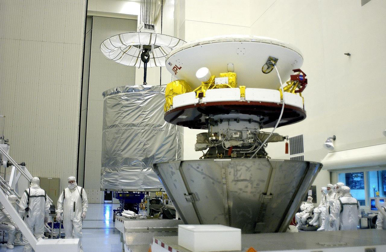 KENNEDY SPACE CENTER, FLA. - In the Payload Hazardous Servicing Facility, an overhead crane (background) begins to lift the canister that will complete encapsulation of the Mars Exploration Rover 2 (MER-2) in the foreground.  After encapsulation, MER-2 will be transferred to Launch Complex 17-A, Cape Canaveral Air Force Station.  MER-2 is one of NASA's twin Mars Exploration Rovers designed to study the history of water on Mars. These robotic geologists are equipped with a robotic arm, a drilling tool, three spectrometers, and four pairs of cameras that allow them to have a human-like, 3D view of the terrain. Each rover could travel as far as 100 meters in one day to act as Mars scientists' eyes and hands, exploring an environment where humans can't yet go.  MER-2 is scheduled to launch no earlier than June 8 as MER-A aboard a Delta II rocket.