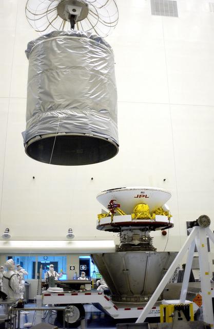 NASA image: KENNEDY SPACE CENTER, FLA. - In the Payload Hazardous Servicing Facility, an overhead crane moves the canister that will complete encapsulation of the Mars Exploration Rover 2 (MER-2), at right.  After encapsulation, MER-2 will be transferred to Launch Complex 17-A, Cape Canaveral Air Force Station.  MER-2 is one of NASA's twin Mars Exploration Rovers designed to study the history of water on Mars. These robotic geologists are equipped with a robotic arm, a drilling tool, three spectrometers, and four pairs of cameras that allow them to have a human-like, 3D view of the terrain. Each rover could travel as far as 100 meters in one day to act as Mars scientists' eyes and hands, exploring an environment where humans can't yet go.  MER-2 is scheduled to launch no earlier than June 8 as MER-A aboard a Delta II rocket.