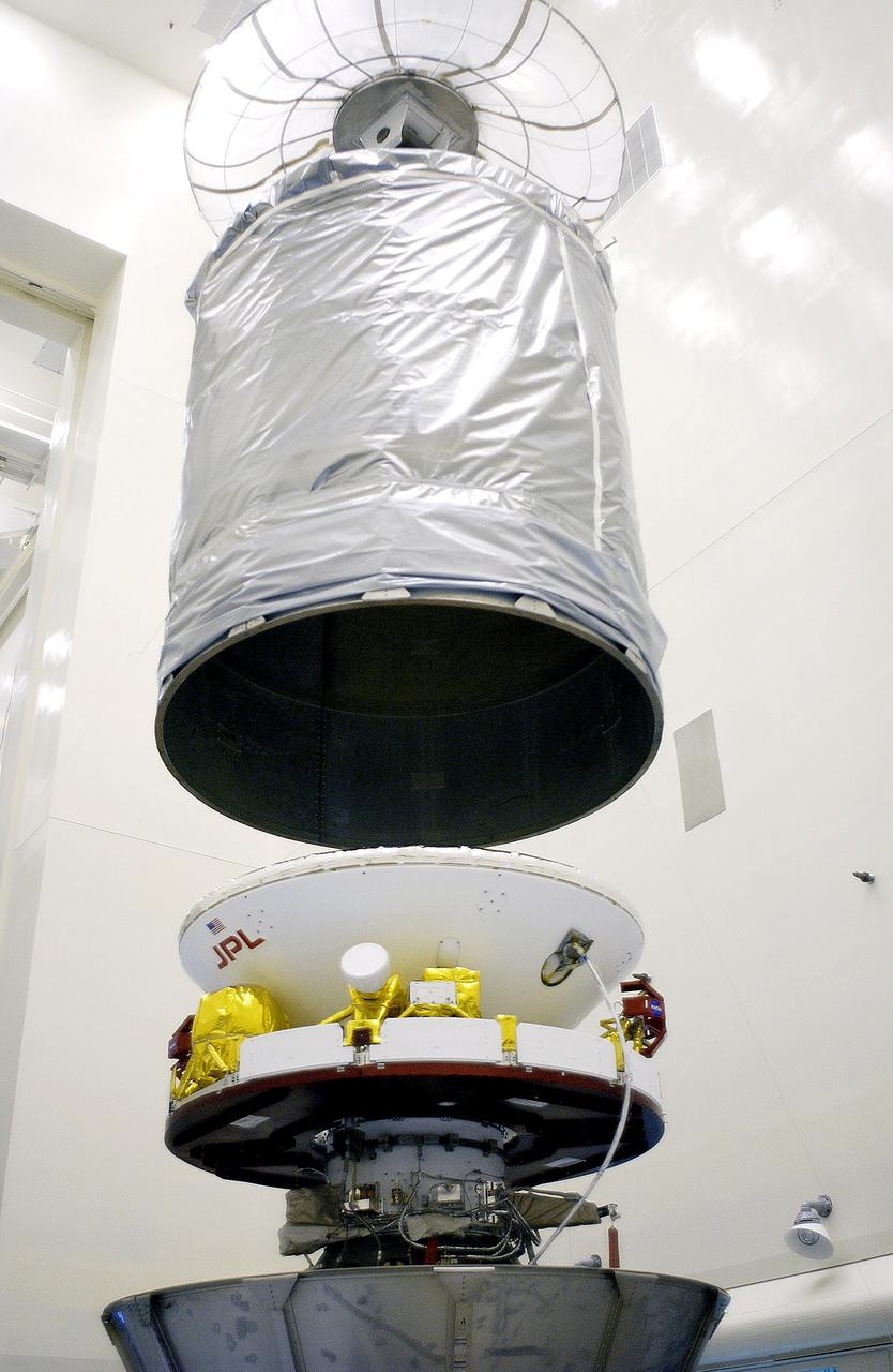 KENNEDY SPACE CENTER, FLA. - In the Payload Hazardous Servicing Facility, an overhead crane lowers the canister that will complete encapsulation of the Mars Exploration Rover 2 (MER-2), at right.  After encapsulation, MER-2 will be transferred to Launch Complex 17-A, Cape Canaveral Air Force Station.  MER-2 is one of NASA's twin Mars Exploration Rovers designed to study the history of water on Mars. These robotic geologists are equipped with a robotic arm, a drilling tool, three spectrometers, and four pairs of cameras that allow them to have a human-like, 3D view of the terrain. Each rover could travel as far as 100 meters in one day to act as Mars scientists' eyes and hands, exploring an environment where humans can't yet go.  MER-2 is scheduled to launch no earlier than June 8 as MER-A aboard a Delta II rocket.