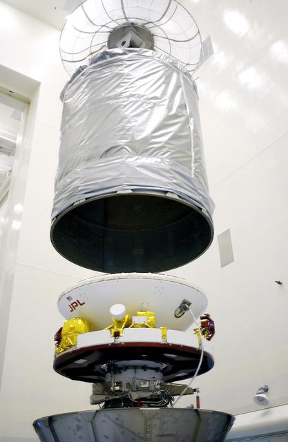 NASA image: KENNEDY SPACE CENTER, FLA. - In the Payload Hazardous Servicing Facility, an overhead crane lowers the canister that will complete encapsulation of the Mars Exploration Rover 2 (MER-2), at right.  After encapsulation, MER-2 will be transferred to Launch Complex 17-A, Cape Canaveral Air Force Station.  MER-2 is one of NASA's twin Mars Exploration Rovers designed to study the history of water on Mars. These robotic geologists are equipped with a robotic arm, a drilling tool, three spectrometers, and four pairs of cameras that allow them to have a human-like, 3D view of the terrain. Each rover could travel as far as 100 meters in one day to act as Mars scientists' eyes and hands, exploring an environment where humans can't yet go.  MER-2 is scheduled to launch no earlier than June 8 as MER-A aboard a Delta II rocket.