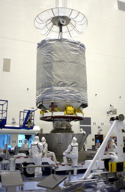 NASA image: KENNEDY SPACE CENTER, FLA. - In the Payload Hazardous Servicing Facility, workers attach the upper canister to the lower portion to encapsulate the Mars Exploration Rover 2 (MER-2).  After encapsulation, MER-2 will be transferred to Launch Complex 17-A, Cape Canaveral Air Force Station.  MER-2 is one of NASA's twin Mars Exploration Rovers designed to study the history of water on Mars. These robotic geologists are equipped with a robotic arm, a drilling tool, three spectrometers, and four pairs of cameras that allow them to have a human-like, 3D view of the terrain. Each rover could travel as far as 100 meters in one day to act as Mars scientists' eyes and hands, exploring an environment where humans can't yet go.  MER-2 is scheduled to launch no earlier than June 8 as MER-A aboard a Delta II rocket.
