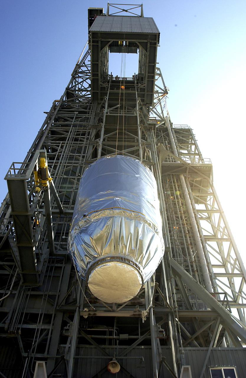 KENNEDY SPACE CENTER, FLA. - On Launch Pad 17-A, Cape Canaveral Air Force Station, the Mars Exploration Rover 2 (MER-2), inside the transport canister, is lifted up the launch tower where it will be mated to the Delta II rocket for launch.  MER-2 is one of NASA's twin Mars Exploration Rovers designed to study the history of water on Mars. These robotic geologists are equipped with a robotic arm, a drilling tool, three spectrometers, and four pairs of cameras that allow them to have a human-like, 3D view of the terrain. Each rover could travel as far as 100 meters in one day to act as Mars scientists' eyes and hands, exploring an environment where humans can't yet go.  MER-2 is scheduled to launch no earlier than June 8 as MER-A.