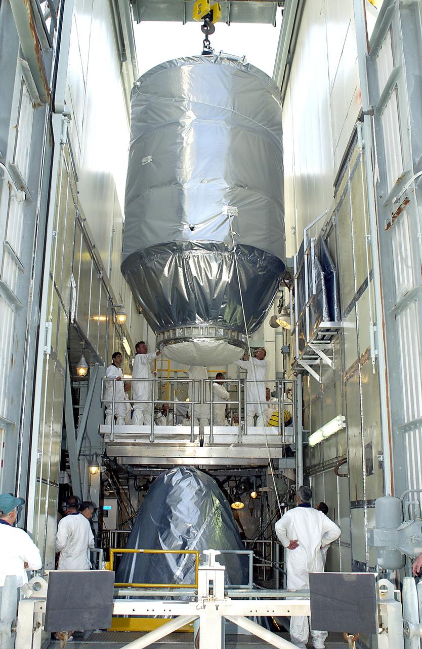 KENNEDY SPACE CENTER, FLA. - On Launch Pad 17-A, Cape Canaveral Air Force Station, the Mars Exploration Rover 2 (MER-2), inside the transport canister, is lowered toward the Delta II rocket for mating.  MER-2 is one of NASA's twin Mars Exploration Rovers designed to study the history of water on Mars. These robotic geologists are equipped with a robotic arm, a drilling tool, three spectrometers, and four pairs of cameras that allow them to have a human-like, 3D view of the terrain. Each rover could travel as far as 100 meters in one day to act as Mars scientists' eyes and hands, exploring an environment where humans can't yet go.  MER-2 is scheduled to launch no earlier than June 8 as MER-A.