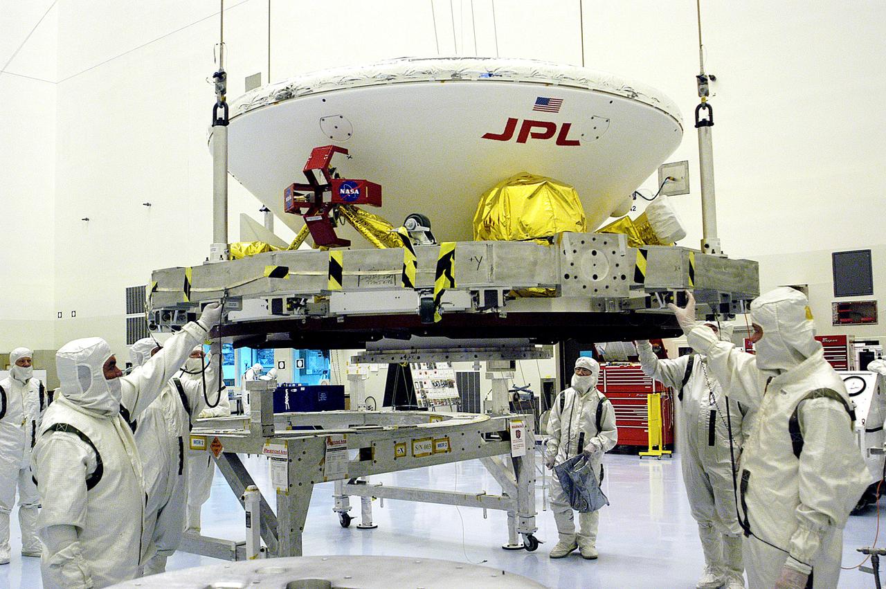 KENNEDY SPACE CENTER, FLA. - In the Payload Hazardous Servicing Facility, workers attach a crane to the Mars Exploration Rover-1 (MER-B) as they prepare to lift it onto a spin table during preflight processing of the spacecraft.  The rover is scheduled to launch aboard a Delta II rocket on June 25.  NASA’s twin Mars Exploration Rovers are designed to study the history of water on Mars. These robotic geologists are equipped with a robotic arm, a drilling tool, three spectrometers, and four pairs of cameras that allow them to have a human-like, 3D view of the terrain. Each rover could travel as far as 100 meters in one day to act as Mars scientists' eyes and hands, exploring an environment where humans are not yet able to go. The launch of MER-2 (MER-A) is tentatively set for June 8.