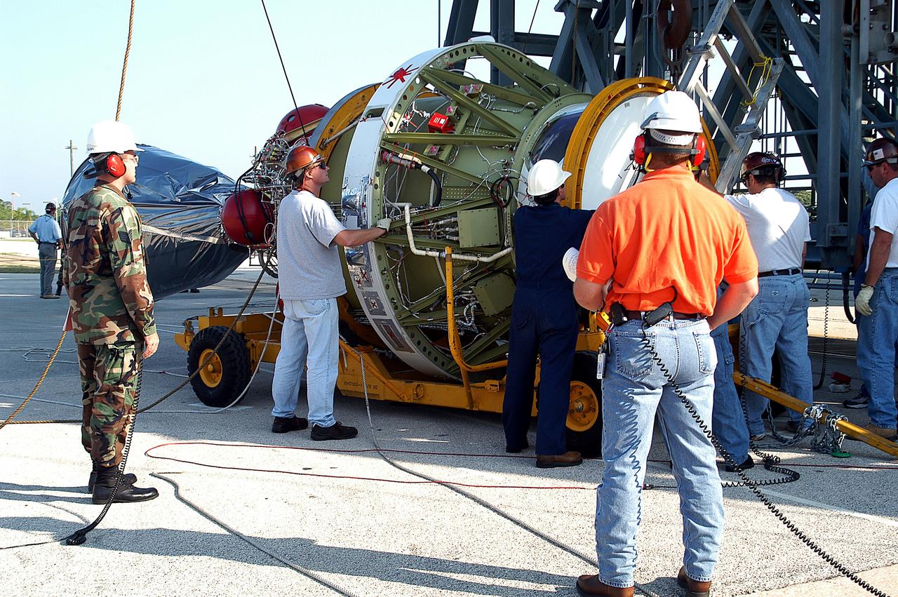 KENNEDY SPACE CENTER, FLA. - Workers prepare to lift the second stage of a Delta II rocket up the launch tower on Pad 17-B, Cape Canaveral Air Force Station.  It will be mated to the Delta first stage already at the pad in preparation for the launch of the Mars Exploration Rover-1 (MER-B) on June 25.  NASA’s twin Mars Exploration Rovers are designed to study the history of water on Mars. These robotic geologists are equipped with a robotic arm, a drilling tool, three spectrometers, and four pairs of cameras that allow them to have a human-like, 3D view of the terrain. Each rover could travel as far as 100 meters in one day to act as Mars scientists' eyes and hands, exploring an environment where humans are not yet able to go. The launch of MER-2 (MER-A) is tentatively set for June 8.