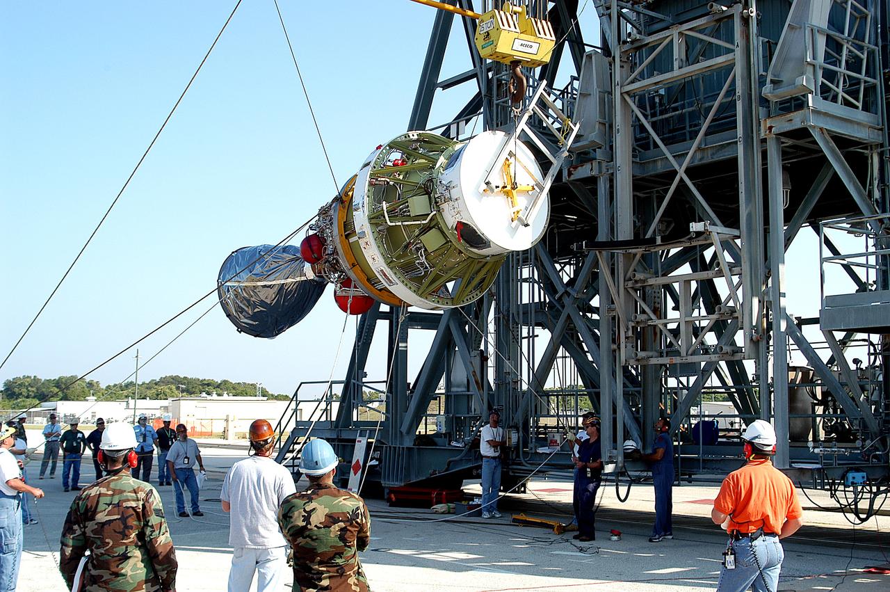 KENNEDY SPACE CENTER, FLA. - Workers begin to lift the second stage of a Delta II rocket up the launch tower on Pad 17-B, Cape Canaveral Air Force Station.  It will be mated to the Delta first stage already at the pad in preparation for the launch of the Mars Exploration Rover-1 (MER-B) on June 25.  NASA’s twin Mars Exploration Rovers are designed to study the history of water on Mars. These robotic geologists are equipped with a robotic arm, a drilling tool, three spectrometers, and four pairs of cameras that allow them to have a human-like, 3D view of the terrain. Each rover could travel as far as 100 meters in one day to act as Mars scientists' eyes and hands, exploring an environment where humans are not yet able to go. The launch of MER-2 (MER-A) is tentatively set for June 8.