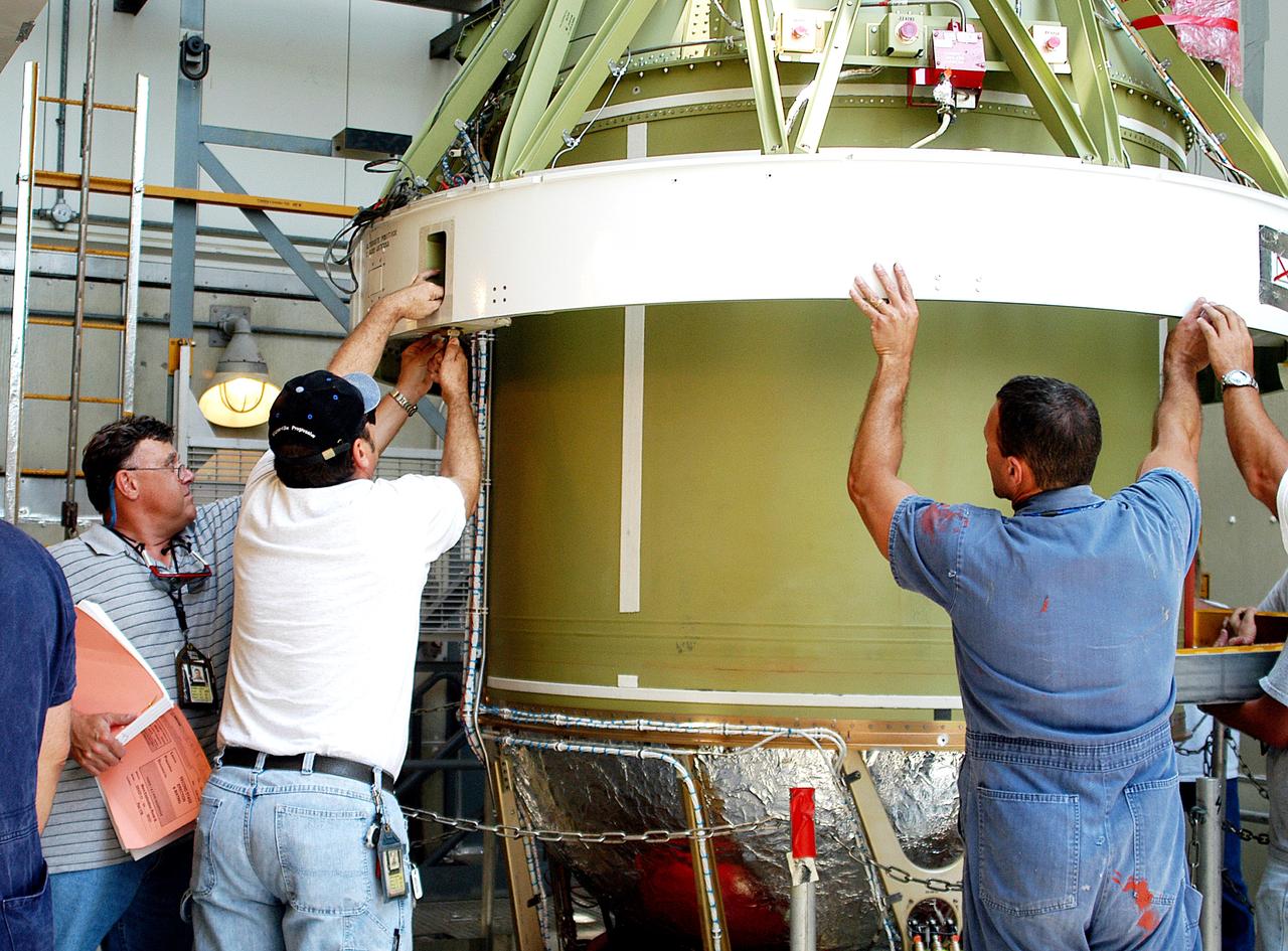 KENNEDY SPACE CENTER, FLA. - The second stage of a Delta II rocket is lowered into positioned above a first stage at Pad 17-B, Cape Canaveral Air Force Station. Next, it will be mated to the first stage in preparation for the launch of the Mars Exploration Rover-1 (MER-B) on June 25.  NASA’s twin Mars Exploration Rovers are designed to study the history of water on Mars. These robotic geologists are equipped with a robotic arm, a drilling tool, three spectrometers, and four pairs of cameras that allow them to have a human-like, 3D view of the terrain. Each rover could travel as far as 100 meters in one day to act as Mars scientists' eyes and hands, exploring an environment where humans are not yet able to go. The launch of MER-2 (MER-A) is tentatively set for June 8.