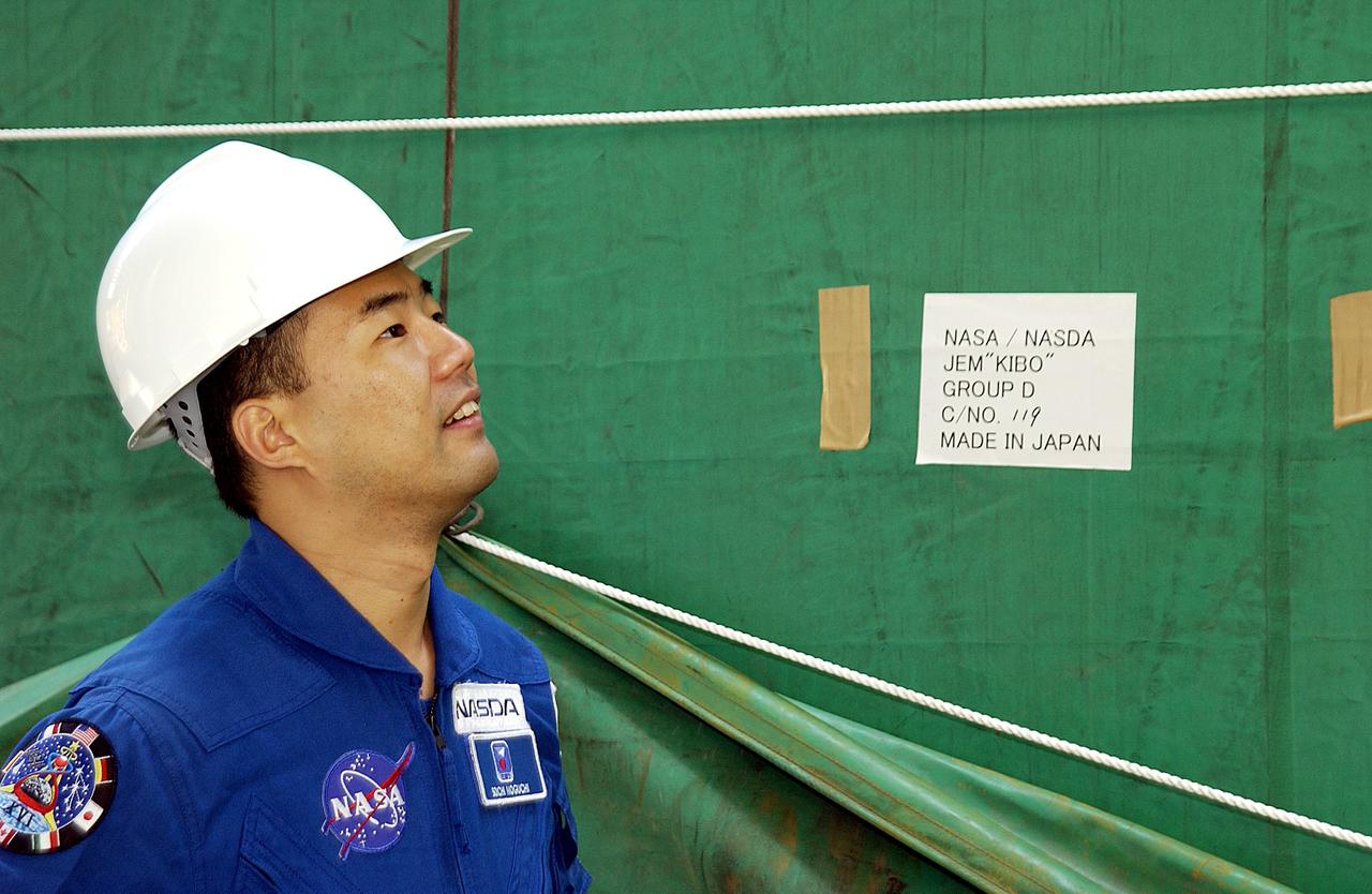 KENNEDY SPACE CENTER, FLA. - Astronaut Soichi Noguchi, with the National Space Development Agency of Japan (NASDA), looks at the Japanese Experiment Module after its arrival at Port Canaveral, Fla.   Built by the Tsukuba Space Center near Tokyo, the pressurized module is the first element of the JEM, Japan’s primary contribution to the space station, to be delivered to KSC. It will enhance the unique research capabilities of the orbiting complex by providing an additional shirt-sleeve environment for astronauts to conduct science experiments. The JEM also includes two logistics modules, an exposed pallet for space environment experiments and a robotic manipulator system that are still under construction in Japan. The various JEM components will be assembled in space over the course of three space shuttle missions.