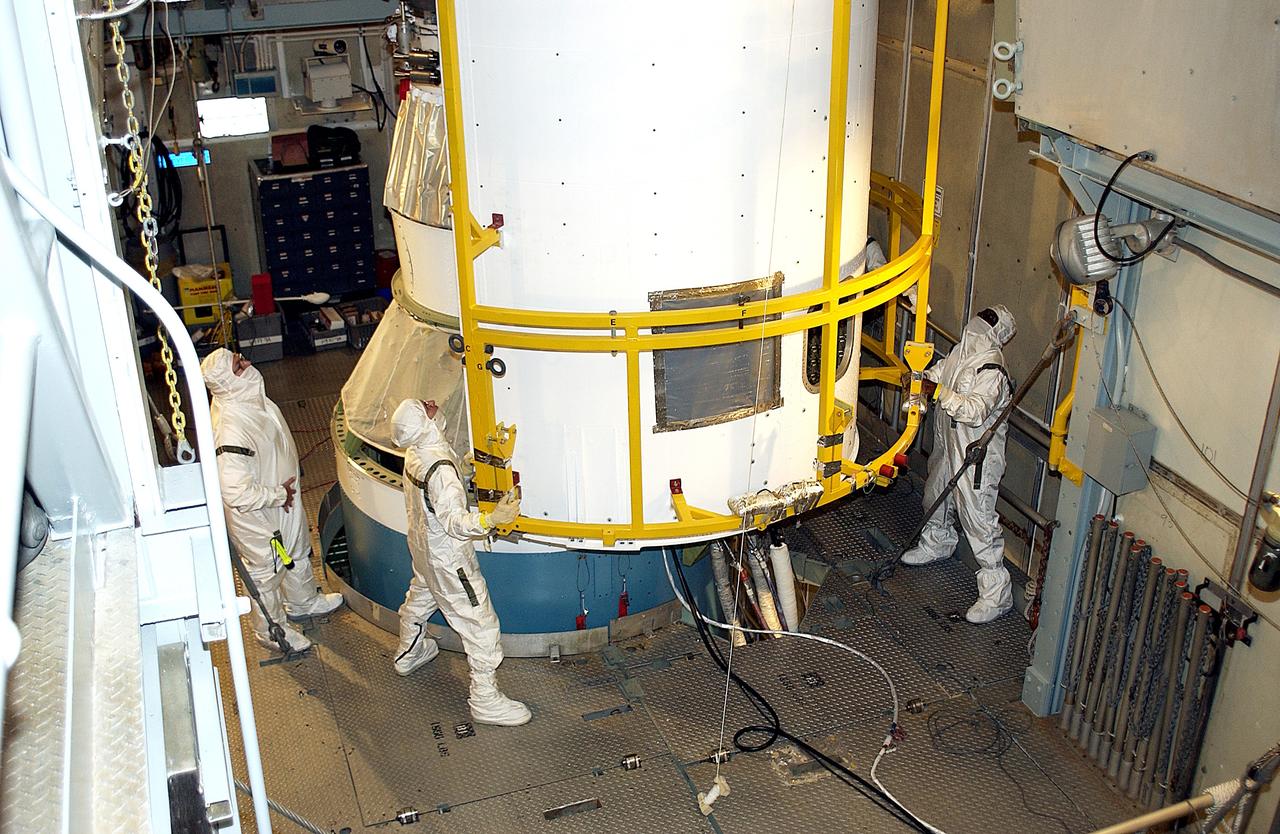 KENNEDY SPACE CENTER, FLA. - At Launch Complex 17-A, Cape Canaveral Air Force Station, the first half of the fairing for the Mars Exploration Rover 2 (MER-2) closes in on the spacecraft.  MER-2 is one of NASA's twin Mars Exploration Rovers designed to study the history of water on Mars. These robotic geologists are equipped with a robotic arm, a drilling tool, three spectrometers, and four pairs of cameras that allow them to have a human-like, 3D view of the terrain. Each rover could travel as far as 100 meters in one day to act as Mars scientists' eyes and hands, exploring an environment where humans can't yet go.  MER-2 is scheduled to launch no earlier than June 8 as MER-A, with two launch opportunities each day during the launch period that closes on June 19.