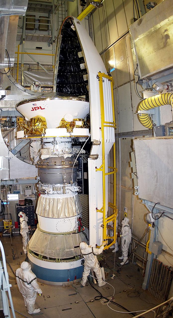 KENNEDY SPACE CENTER, FLA. - At Launch Complex 17-A, Cape Canaveral Air Force Station, the first half of the fairing for the Mars Exploration Rover 2 (MER-2) closes in on the spacecraft.  MER-2 is one of NASA's twin Mars Exploration Rovers designed to study the history of water on Mars. These robotic geologists are equipped with a robotic arm, a drilling tool, three spectrometers, and four pairs of cameras that allow them to have a human-like, 3D view of the terrain. Each rover could travel as far as 100 meters in one day to act as Mars scientists' eyes and hands, exploring an environment where humans can't yet go.  MER-2 is scheduled to launch no earlier than June 8 as MER-A, with two launch opportunities each day during the launch period that closes on June 19.