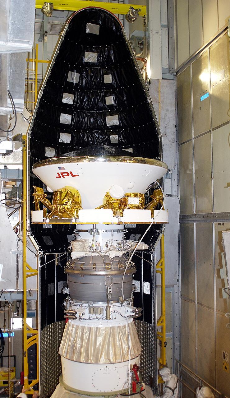 KENNEDY SPACE CENTER, FLA. - At Launch Complex 17-A, Cape Canaveral Air Force Station, the first half of the fairing for the Mars Exploration Rover 2 (MER-2) is seen behind the spacecraft.  MER-2 is one of NASA's twin Mars Exploration Rovers designed to study the history of water on Mars. These robotic geologists are equipped with a robotic arm, a drilling tool, three spectrometers, and four pairs of cameras that allow them to have a human-like, 3D view of the terrain. Each rover could travel as far as 100 meters in one day to act as Mars scientists' eyes and hands, exploring an environment where humans can't yet go.  MER-2 is scheduled to launch no earlier than June 8 as MER-A, with two launch opportunities each day during the launch period that closes on June 19.