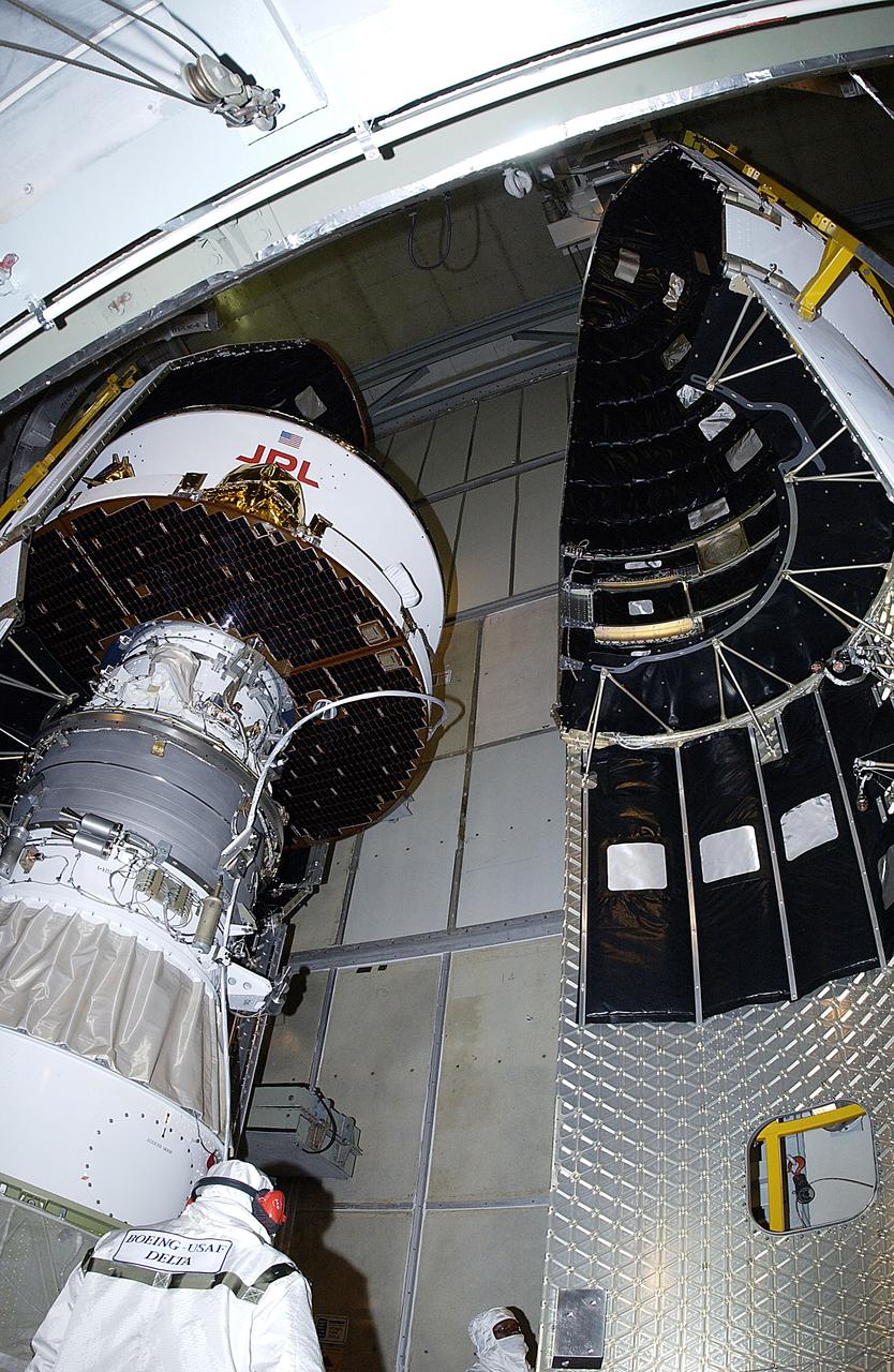 KENNEDY SPACE CENTER, FLA. -  The second half of the fairing is moved toward the Mars Exploration Rover 2 (MER-2) on Launch Complex 17-A, Cape Canaveral Air Force Station.  MER-2 is one of NASA's twin Mars Exploration Rovers designed to study the history of water on Mars. These robotic geologists are equipped with a robotic arm, a drilling tool, three spectrometers, and four pairs of cameras that allow them to have a human-like, 3D view of the terrain. Each rover could travel as far as 100 meters in one day to act as Mars scientists' eyes and hands, exploring an environment where humans can't yet go.  MER-2 is scheduled to launch no earlier than June 8 as MER-A, with two launch opportunities each day during the launch period that closes on June 19.
