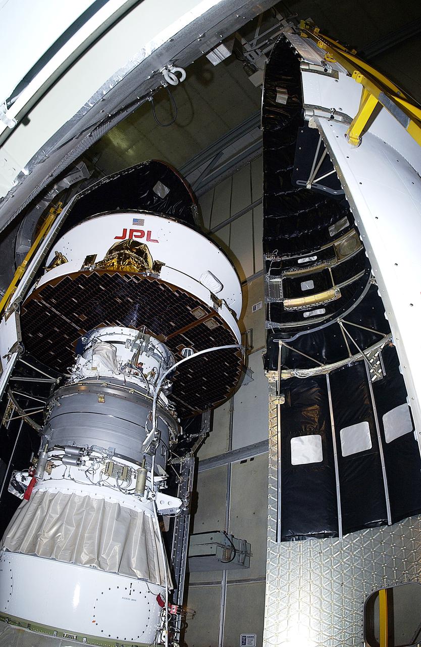 KENNEDY SPACE CENTER, FLA. - The second half of the fairing is moved toward the Mars Exploration Rover 2 (MER-2) on Launch Complex 17-A, Cape Canaveral Air Force Station.  MER-2 is one of NASA's twin Mars Exploration Rovers designed to study the history of water on Mars. These robotic geologists are equipped with a robotic arm, a drilling tool, three spectrometers, and four pairs of cameras that allow them to have a human-like, 3D view of the terrain. Each rover could travel as far as 100 meters in one day to act as Mars scientists' eyes and hands, exploring an environment where humans can't yet go.  MER-2 is scheduled to launch no earlier than June 8 as MER-A, with two launch opportunities each day during the launch period that closes on June 19.