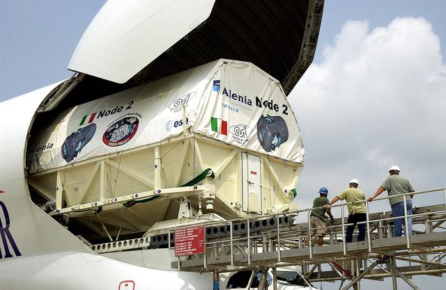 NASA image: KENNEDY SPACE CENTER, FLA. - The Italian-built module, U.S. Node 2, for the International Space Station is offloaded from a Beluga aircraft at the Shuttle Landing Facility. The second of three Station connecting modules, Node 2 attaches to the end of the U.S. Lab and provides attach locations for the Japanese laboratory, European laboratory, the Centrifuge Accommodation Module and, later, Multipurpose Logistics Modules. It will provide the primary docking location for the Shuttle when a pressurized mating adapter is attached to Node 2.  Installation of the module will complete  the U.S. Core of the ISS.  Node 2 is the designated payload for mission STS-120.  No orbiter or launch date has been determined yet.