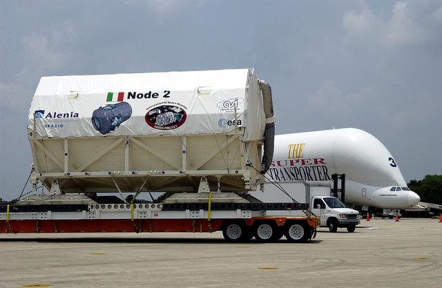 NASA image: KENNEDY SPACE CENTER, FLA. -  The Italian-built module, U.S. Node 2, moves past the Beluga aircraft that brought it to KSC as it is transferred to the Space Station Processing Facility. The second of three connecting modules on the International Space Station, Node 2 attaches to the end of the U.S. Lab and provides attach locations for the Japanese laboratory, European laboratory, the Centrifuge Accommodation Module and, later, Multipurpose Logistics Modules. It will provide the primary docking location for the Shuttle when a pressurized mating adapter is attached to Node 2.  Installation of the module will complete  the U.S. Core of the ISS.  Node 2 is the designated payload for mission STS-120.  No orbiter or launch date has been determined yet.