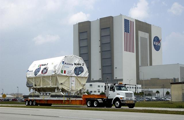 NASA image: KENNEDY SPACE CENTER, FLA. -  The Italian-built module, U.S. Node 2, moves past the Vehicle Assembly Building as it is transferred to the Space Station Processing Facility. The second of three connecting modules on the International Space Station, Node 2 attaches to the end of the U.S. Lab and provides attach locations for the Japanese laboratory, European laboratory, the Centrifuge Accommodation Module and, later, Multipurpose Logistics Modules. It will provide the primary docking location for the Shuttle when a pressurized mating adapter is attached to Node 2.  Installation of the module will complete  the U.S. Core of the ISS.  Node 2 is the designated payload for mission STS-120.  No orbiter or launch date has been determined yet.