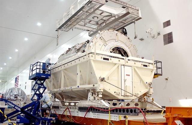 NASA image: KENNEDY SPACE CENTER, FLA. - An overhead crane in the Space Station Processing Facility is attached to the U.S. Node 2 to lift it out of its shipping container.  The node will be moved to a workstand.  The second of three connecting modules on the International Space Station, the Italian-built Node 2 attaches to the end of the U.S. Lab and provides attach locations for the Japanese laboratory, European laboratory, the Centrifuge Accommodation Module and, later, Multipurpose Logistics Modules. It will provide the primary docking location for the Shuttle when a pressurized mating adapter is attached to Node 2.  Installation of the module will complete  the U.S. Core of the ISS.  Node 2 is the designated payload for mission STS-120.  No orbiter or launch date has been determined yet.