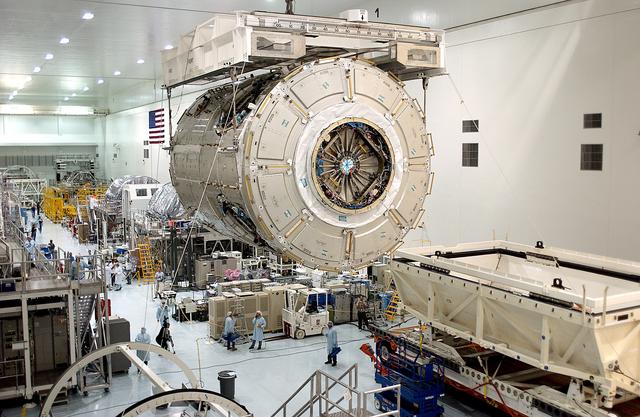 NASA image: KENNEDY SPACE CENTER, FLA. - An overhead crane in the Space Station Processing Facility carries the U.S. Node 2 across the floor to a workstand.  The second of three connecting modules on the International Space Station, the Italian-built Node 2 attaches to the end of the U.S. Lab and provides attach locations for the Japanese laboratory, European laboratory, the Centrifuge Accommodation Module and, later, Multipurpose Logistics Modules. It will provide the primary docking location for the Shuttle when a pressurized mating adapter is attached to Node 2.  Installation of the module will complete  the U.S. Core of the ISS.  Node 2 is the designated payload for mission STS-120.  No orbiter or launch date has been determined yet.