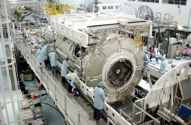 NASA image: KENNEDY SPACE CENTER, FLA. -  The U.S. Node 2 is lowered onto a workstand in the Space Station Processing Facility.  The second of three connecting modules on the International Space Station, the Italian-built Node 2 attaches to the end of the U.S. Lab and provides attach locations for the Japanese laboratory, European laboratory, the Centrifuge Accommodation Module and, later, Multipurpose Logistics Modules. It will provide the primary docking location for the Shuttle when a pressurized mating adapter is attached to Node 2.  Installation of the module will complete  the U.S. Core of the ISS.  Node 2 is the designated payload for mission STS-120.  No orbiter or launch date has been determined yet.