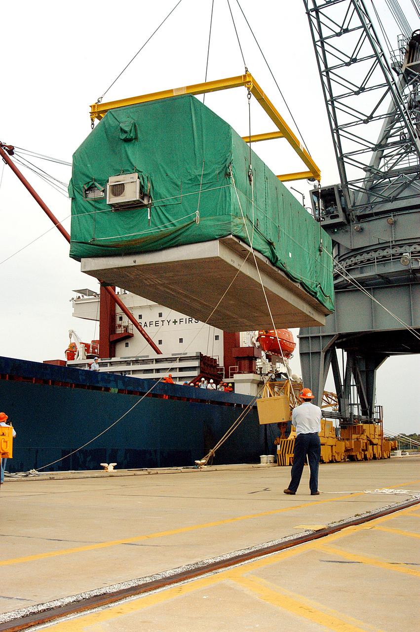 KENNEDY SPACE CENTER, FLA. - At Port Canaveral, the Pressurized Module of the Japanese Experiment Module (JEM) is suspended over the dock, waiting for a truck that will transfer it to KSC’s Space Station Processing Facility. The container transport ship carrying JEM departed May 2 from Yokohama Harbor in Japan for the voyage to the United States. The National Space Development Agency of Japan (NASDA) developed the laboratory at the Tsukuba Space Center near Tokyo.  The Pressurized Module is the first element of the JEM, named "Kibo" (Hope), to be delivered to KSC. The JEM is Japan's primary contribution to the Station. It will enhance the unique research capabilities of the orbiting complex by providing an additional environment for astronauts to conduct science experiments.  The JEM also includes an exposed facility (platform) for space environment experiments, a robotic manipulator system, and two logistics modules. The various JEM components will be  assembled in space over the course of three Shuttle missions.