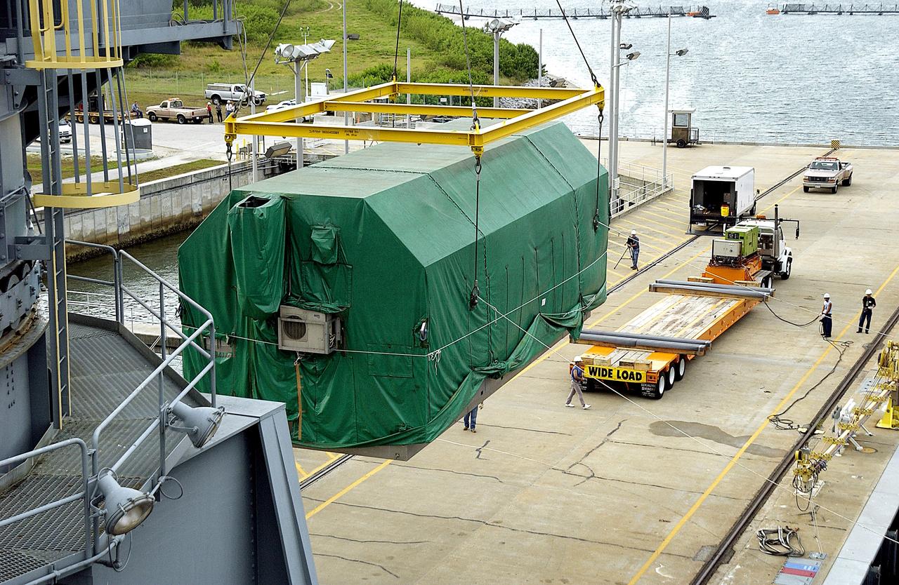 KENNEDY SPACE CENTER, FLA. - At Port Canaveral, the Pressurized Module of the Japanese Experiment Module (JEM) is lifted out of the ship’s cargo hold.  It will be loaded onto the truck bed in the background for transfer to KSC’s Space Station Processing Facility.  The container transport ship carrying JEM departed May 2 from Yokohama Harbor in Japan for the voyage to the United States. The National Space Development Agency of Japan (NASDA) developed the laboratory at the Tsukuba Space Center near Tokyo. The Pressurized Module is the first element of the JEM, named "Kibo" (Hope), to be delivered to KSC. The JEM is Japan's primary contribution to the Station. It will enhance the unique research capabilities of the orbiting complex by providing an additional environment for astronauts to conduct science experiments.  The JEM also includes an exposed facility (platform) for space environment experiments, a robotic manipulator system, and two logistics modules. The various JEM components will be  assembled in space over the course of three Shuttle missions.