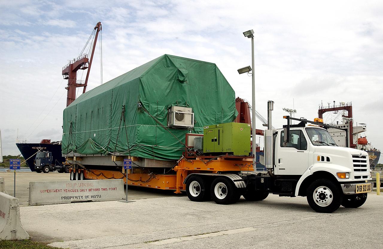 KENNEDY SPACE CENTER, FLA. -  The transporter rolls out of Port Canaveral with the Pressurized Module of the Japanese Experiment Module (JEM) aboard.  The National Space Development Agency of Japan (NASDA) developed the laboratory at the Tsukuba Space Center near Tokyo. The Pressurized Module is the first element of the JEM, named "Kibo" (Hope), to be delivered to KSC, and will be transferred to KSC’s Space Station Processing Facility.  The JEM is Japan's primary contribution to the Station. It will enhance the unique research capabilities of the orbiting complex by providing an additional environment for astronauts to conduct science experiments.  The JEM also includes an exposed facility (platform) for space environment experiments, a robotic manipulator system, and two logistics modules. The various JEM components will be  assembled in space over the course of three Shuttle missions.