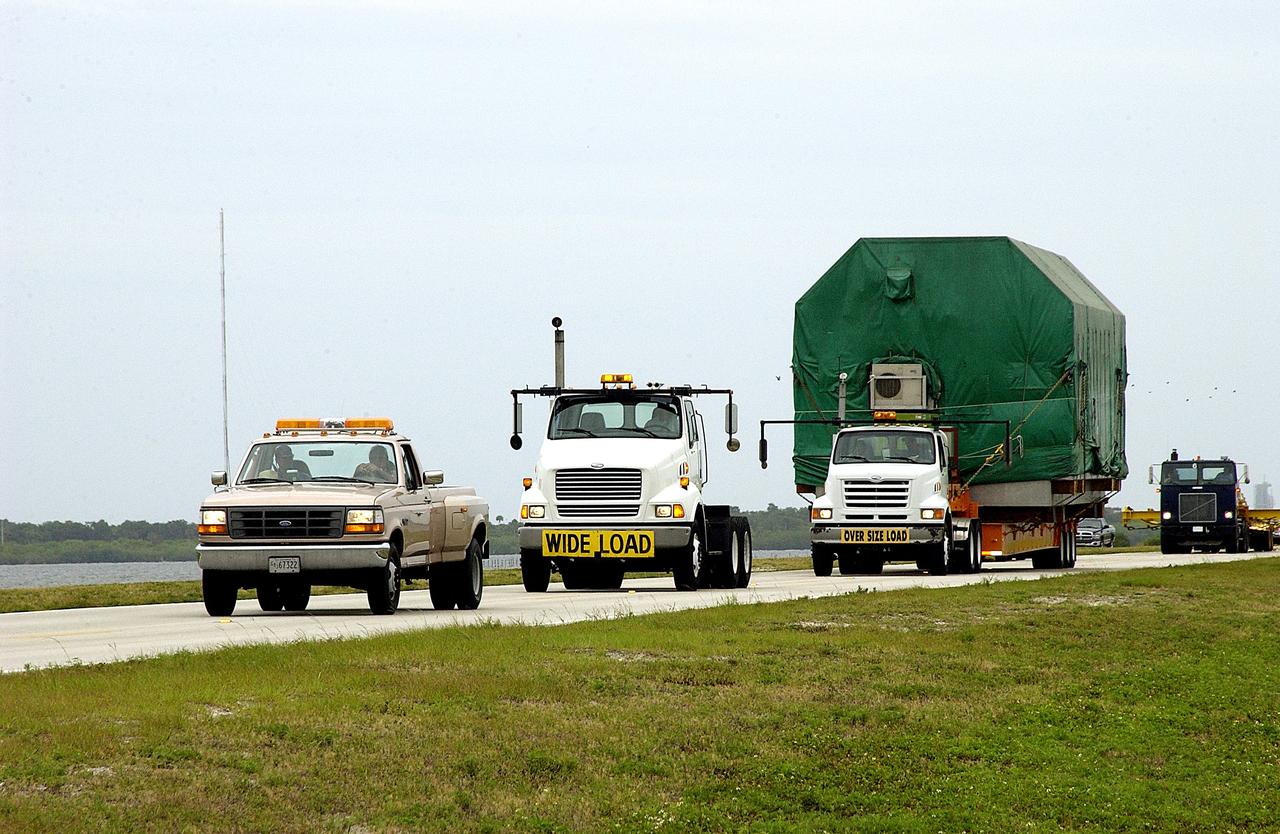 KENNEDY SPACE CENTER, FLA. -  A convoy accompanies the truck transporting the Pressurized Module of the Japanese Experiment Module (JEM) to KSC’s Space Station Processing Facility.  The National Space Development Agency of Japan (NASDA) developed the laboratory at the Tsukuba Space Center near Tokyo. The Pressurized Module is the first element of the JEM, named "Kibo" (Hope), to be delivered to KSC.  The JEM is Japan's primary contribution to the Station. It will enhance the unique research capabilities of the orbiting complex by providing an additional environment for astronauts to conduct science experiments.  The JEM also includes an exposed facility (platform) for space environment experiments, a robotic manipulator system, and two logistics modules. The various JEM components will be  assembled in space over the course of three Shuttle missions.