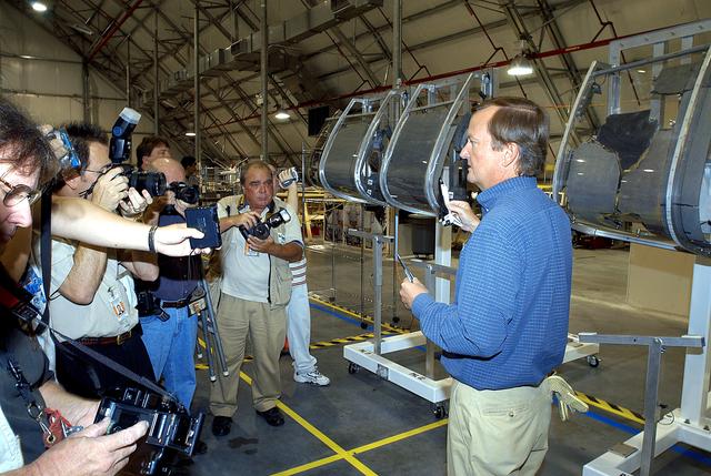 NASA image: KENNEDY SPACE CENTER, FLA. -  In the Columbia Debris Hangar,  Shuttle Launch Director Mike Leinbach  (right) talks to the media about activities that have taken place since the Columbia accident on Feb. 1, 2003.  STS-107 debris recovery and reconstruction operations are winding down.  To date, nearly 84,000 pieces of debris have been recovered and sent to KSC. That represents about 38 percent of the dry weight of Columbia, equaling almost 85,000 pounds.