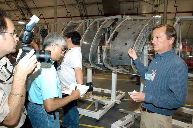 NASA image: KENNEDY SPACE CENTER, FLA. - In the Columbia Debris Hangar,  Shuttle Launch Director Mike Leinbach  (right) talks to the media about activities that have taken place since the Columbia accident on Feb. 1, 2003.  STS-107 debris recovery and reconstruction operations are winding down.  To date, nearly 84,000 pieces of debris have been recovered and sent to KSC. That represents about 38 percent of the dry weight of Columbia, equaling almost 85,000 pounds.