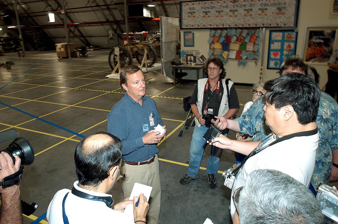 KENNEDY SPACE CENTER, FLA. - In the Columbia Debris Hangar,  Shuttle Launch Director Mike Leinbach  (right) talks to the media about activities that have taken place since the Columbia accident on Feb. 1, 2003.  STS-107 debris recovery and reconstruction operations are winding down.  To date, nearly 84,000 pieces of debris have been recovered and sent to KSC. That represents about 38 percent of the dry weight of Columbia, equaling almost 85,000 pounds.
