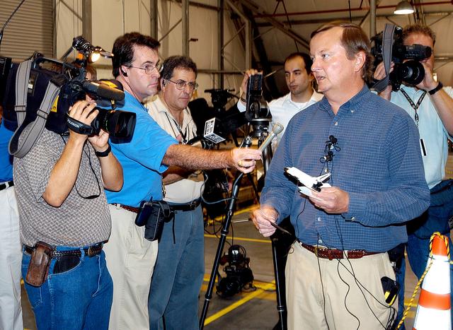 KENNEDY SPACE CENTER, FLA. - In the Columbia Debris Hangar,  Shuttle Launch Director Mike Leinbach  points to some of the debris as he explains to the media about activities that have taken place since the Columbia accident on Feb. 1, 2003.  STS-107 debris recovery and reconstruction operations are winding down.  To date, nearly 84,000 pieces of debris have been recovered and sent to KSC. That represents about 38 percent of the dry weight of Columbia, equaling almost 85,000 pounds.