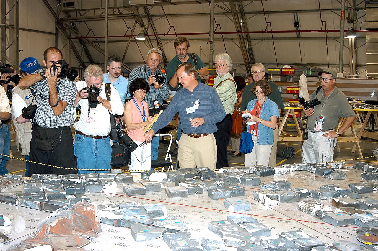 KENNEDY SPACE CENTER, FLA. -  In the Columbia Debris Hangar,  Shuttle Launch Director Mike Leinbach  points to some of the tiles recovered from the orbiter as he explains to the media about activities that have taken place since the Columbia accident on Feb. 1, 2003.  STS-107 debris recovery and reconstruction operations are winding down.  To date, nearly 84,000 pieces of debris have been recovered and sent to KSC. That represents about 38 percent of the dry weight of Columbia, equaling almost 85,000 pounds.