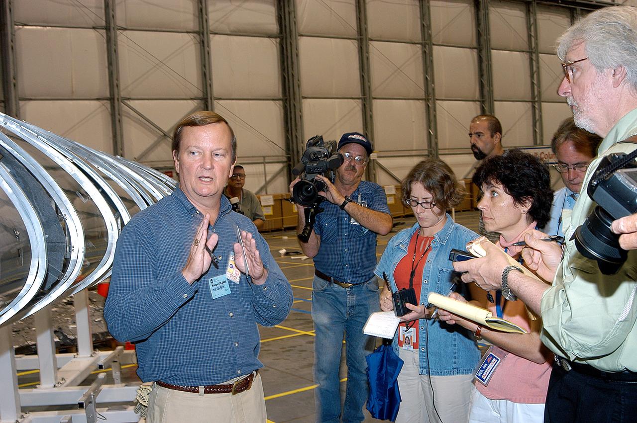 KENNEDY SPACE CENTER, FLA. -  In the Columbia Debris Hangar,  Shuttle Launch Director Mike Leinbach  (left) talks to the media about activities that have taken place since the Columbia accident on Feb. 1, 2003.  Behind him is a model of the left wing of the orbiter.  STS-107 debris recovery and reconstruction operations are winding down.  To date, nearly 84,000 pieces of debris have been recovered and sent to KSC. That represents about 38 percent of the dry weight of Columbia, equaling almost 85,000 pounds.