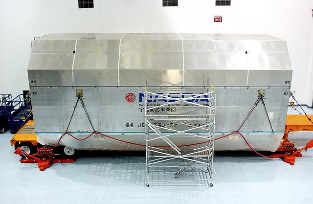 NASA image: KENNEDY SPACE CENTER, FLA. - The container with the Japanese Experiment Module (JEM)’s pressurized module is inside the Space Station Processing Facility.  The National Space Development Agency of Japan (NASDA) developed the laboratory at the Tsukuba Space Center near Tokyo. The Pressurized Module is the first element of the JEM, named "Kibo" (Hope), to be delivered to KSC. The JEM is Japan's primary contribution to the Station. It will enhance the unique research capabilities of the orbiting complex by providing an additional environment for astronauts to conduct science experiments.  The JEM also includes an exposed facility (platform) for space environment experiments, a robotic manipulator system, and two logistics modules. The various JEM components will be  assembled in space over the course of three Shuttle missions.