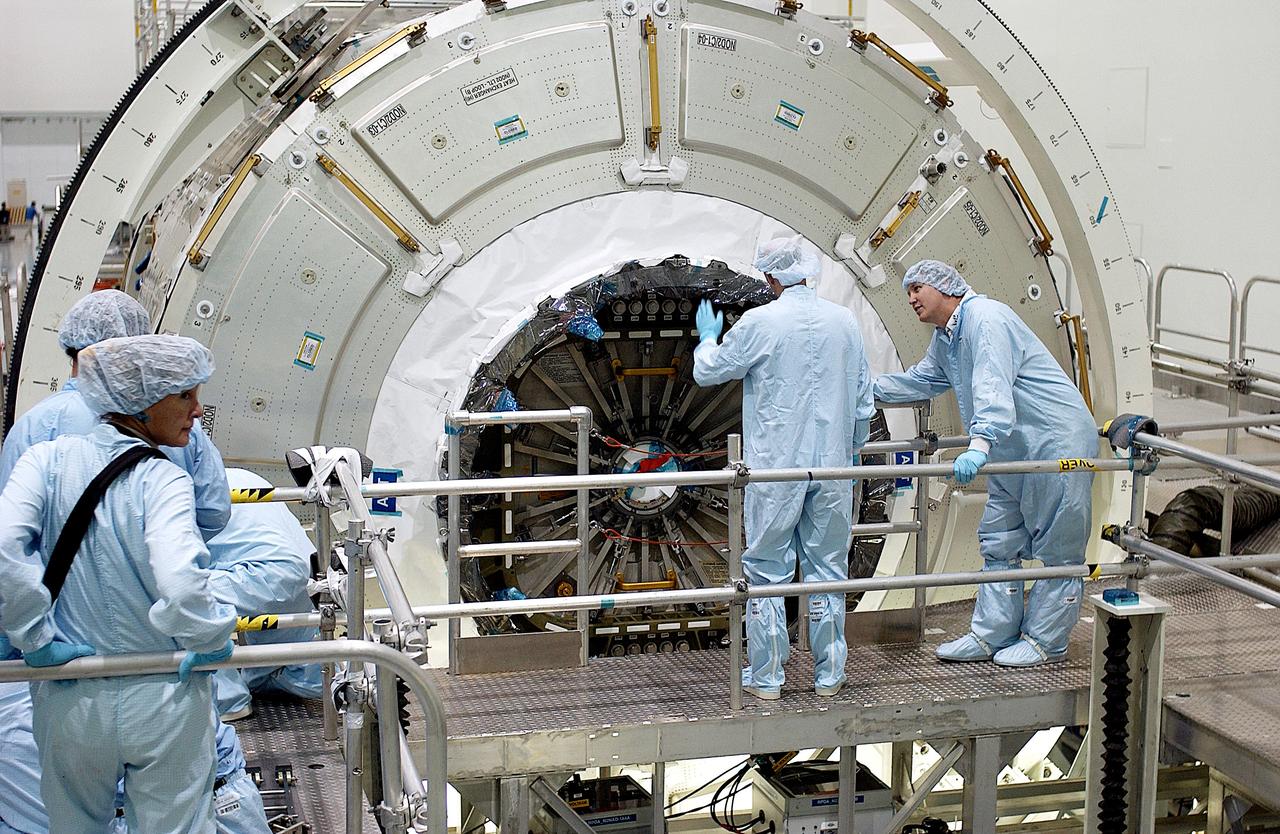 KENNEDY SPACE CENTER, FLA. -  Workers in the Space Station Processing Facility look over the hatch on the Italian-built Node 2, a future element of the International Space Station.  Node 2 arrived at KSC June 1.  The second of three Station connecting modules, the module  attaches to the end of the U.S. Lab and provides attach locations for the Japanese laboratory, European laboratory, the Centrifuge Accommodation Module and, later, Multipurpose Logistics Modules. It will provide the primary docking location for the Shuttle when a pressurized mating adapter is attached to Node 2.  Installation of the module will complete  the U.S. Core of the ISS.  Node 2 is the designated payload for mission STS-120.  No orbiter or launch date has been determined yet.