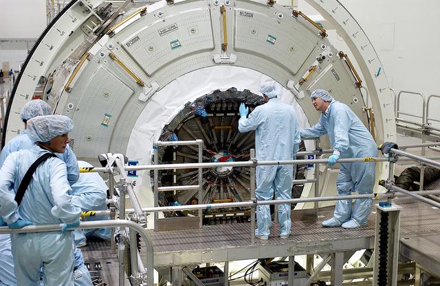 KENNEDY SPACE CENTER, FLA. -  Workers in the Space Station Processing Facility look over the hatch on the Italian-built Node 2, a future element of the International Space Station.  Node 2 arrived at KSC June 1.  The second of three Station connecting modules, the module  attaches to the end of the U.S. Lab and provides attach locations for the Japanese laboratory, European laboratory, the Centrifuge Accommodation Module and, later, Multipurpose Logistics Modules. It will provide the primary docking location for the Shuttle when a pressurized mating adapter is attached to Node 2.  Installation of the module will complete  the U.S. Core of the ISS.  Node 2 is the designated payload for mission STS-120.  No orbiter or launch date has been determined yet.