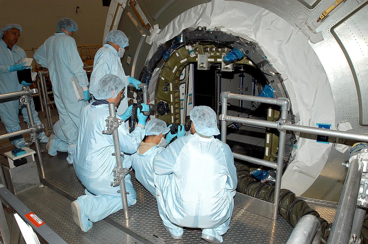 KENNEDY SPACE CENTER, FLA. -  Workers in the Space Station Processing Facility attempt to open the hatch on the Italian-built Node 2, a future element of the International Space Station.  Node 2 arrived at KSC June 1.  The second of three Station connecting modules, the module  attaches to the end of the U.S. Lab and provides attach locations for the Japanese laboratory, European laboratory, the Centrifuge Accommodation Module and, later, Multipurpose Logistics Modules. It will provide the primary docking location for the Shuttle when a pressurized mating adapter is attached to Node 2.  Installation of the module will complete  the U.S. Core of the ISS.  Node 2 is the designated payload for mission STS-120.  No orbiter or launch date has been determined yet.Installation of the module will complete  the U.S. Core of the ISS.  Node 2 is the designated payload for mission STS-120.  No orbiter or launch date has been determined yet.