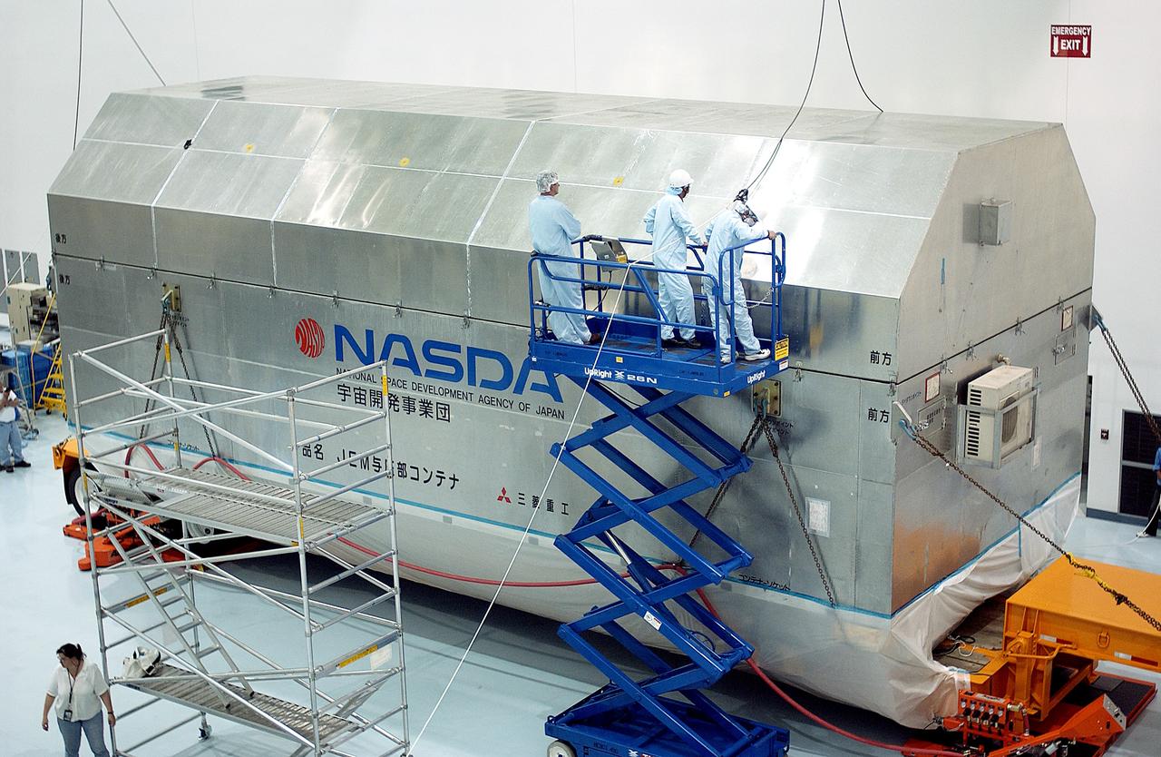 KENNEDY SPACE CENTER, FLA. -   Workers in the Space Station Processing Facility prepare to remove the lid of the container with the Japanese Experiment Module (JEM) pressure module inside. A research laboratory, the pressurized module is the first element of the JEM, named "Kibo" (Hope), to be delivered to KSC.   The National Space Development Agency of Japan (NASDA) developed the laboratory at the Tsukuba Space Center near Tokyo and is Japan's primary contribution to the Station. It will enhance the unique research capabilities of the orbiting complex by providing an additional environment for astronauts to conduct science experiments.  The JEM also includes an exposed facility (platform) for space environment experiments, a robotic manipulator system, and two logistics modules. The various JEM components will be  assembled in space over the course of three Shuttle missions.
