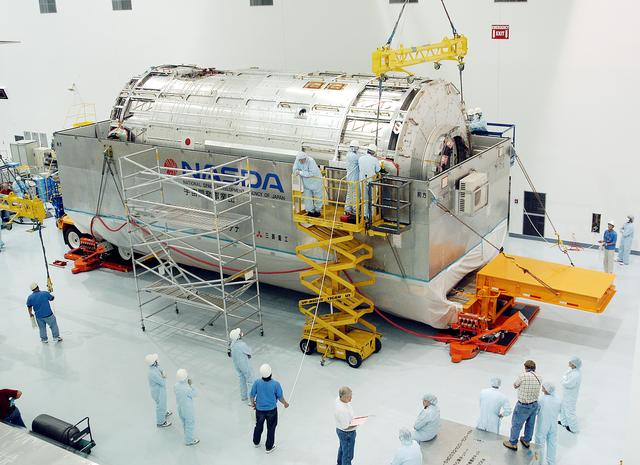 NASA image: KENNEDY SPACE CENTER, FLA. -  An overhead crane is attached to the Japanese Experiment Module (JEM) pressure module inside its canister.  The module will be removed and transferred to a work stand in the Space Station Processing Facility.  A research laboratory, the pressurized module is the first element of the JEM, named "Kibo" (Hope), to be delivered to KSC.   The National Space Development Agency of Japan (NASDA) developed the laboratory at the Tsukuba Space Center near Tokyo and is Japan's primary contribution to the Station. It will enhance the unique research capabilities of the orbiting complex by providing an additional environment for astronauts to conduct science experiments.  The JEM also includes an exposed facility (platform) for space environment experiments, a robotic manipulator system, and two logistics modules. The various JEM components will be  assembled in space over the course of three Shuttle missions.