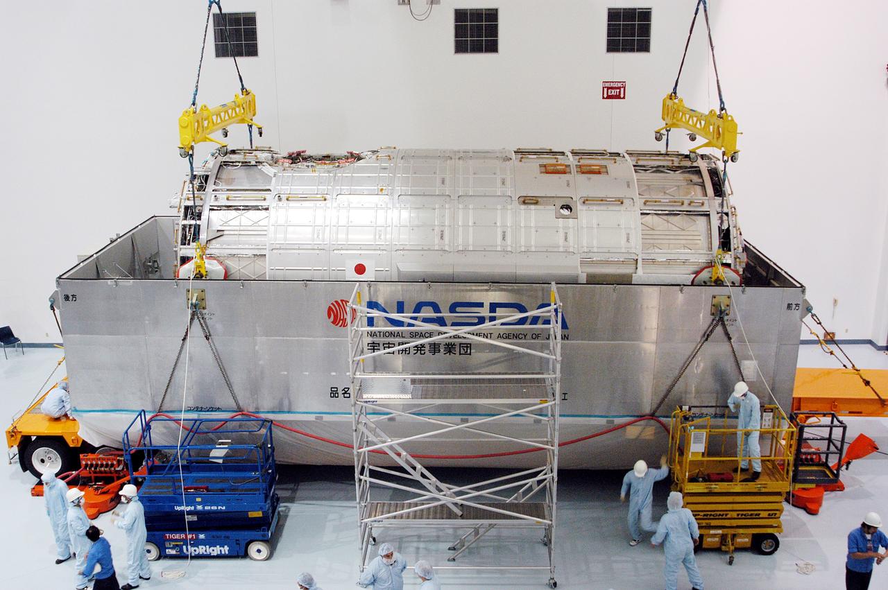 KENNEDY SPACE CENTER, FLA. -  In the Space Station Processing Facility, an overhead crane begins to lift the Japanese Experiment Module (JEM) pressure module out of the shipping canister to move it to a work stand.  A research laboratory, the pressurized module is the first element of the JEM, named "Kibo" (Hope), to be delivered to KSC.   The National Space Development Agency of Japan (NASDA) developed the laboratory at the Tsukuba Space Center near Tokyo and is Japan's primary contribution to the Station. It will enhance the unique research capabilities of the orbiting complex by providing an additional environment for astronauts to conduct science experiments.  The JEM also includes an exposed facility (platform) for space environment experiments, a robotic manipulator system, and two logistics modules. The various JEM components will be  assembled in space over the course of three Shuttle missions.