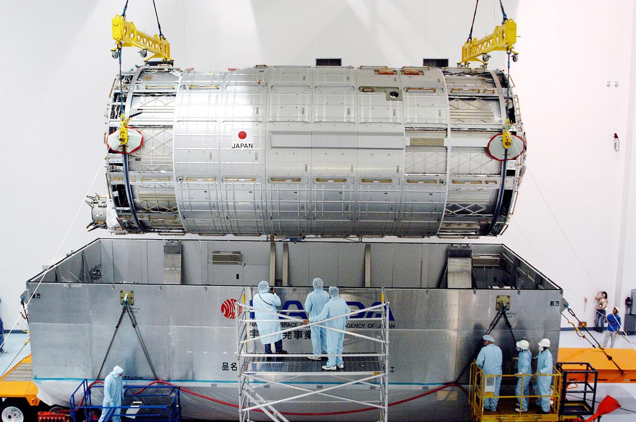 KENNEDY SPACE CENTER, FLA. -  In the Space Station Processing Facility, an overhead crane lifts the Japanese Experiment Module (JEM) pressure module out of the shipping canister to move it to a work stand.  A research laboratory, the pressurized module is the first element of the JEM, named "Kibo" (Hope), to be delivered to KSC.   The National Space Development Agency of Japan (NASDA) developed the laboratory at the Tsukuba Space Center near Tokyo and is Japan's primary contribution to the Station. It will enhance the unique research capabilities of the orbiting complex by providing an additional environment for astronauts to conduct science experiments.  The JEM also includes an exposed facility (platform) for space environment experiments, a robotic manipulator system, and two logistics modules. The various JEM components will be  assembled in space over the course of three Shuttle missions.