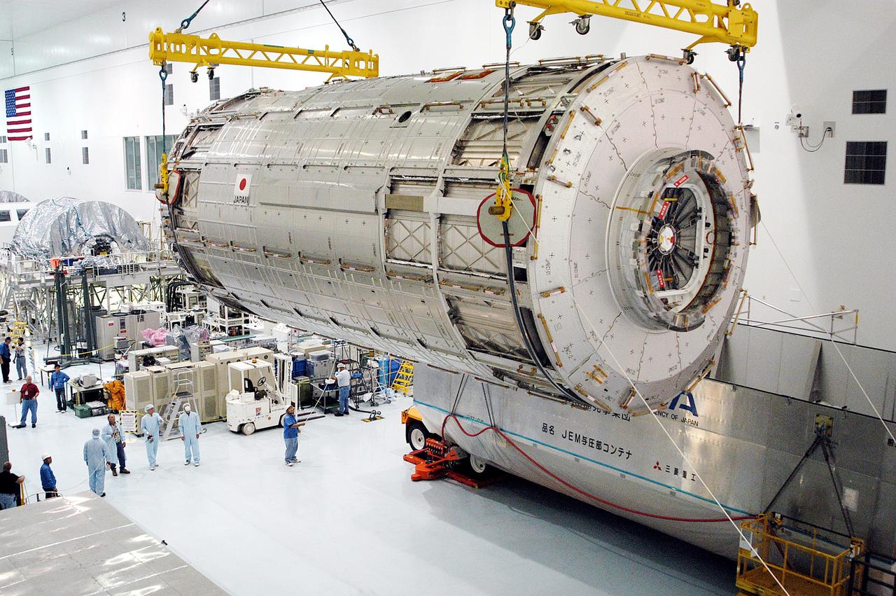 KENNEDY SPACE CENTER, FLA. -   Removed from its shipping canister (lower right), the Japanese Experiment Module (JEM) pressure module is moved across the floor of the Space Station Processing Facility to a work stand.  A research laboratory, the pressurized module is the first element of the JEM, named "Kibo" (Hope), to be delivered to KSC.   The National Space Development Agency of Japan (NASDA) developed the laboratory at the Tsukuba Space Center near Tokyo and is Japan's primary contribution to the Station. It will enhance the unique research capabilities of the orbiting complex by providing an additional environment for astronauts to conduct science experiments.  The JEM also includes an exposed facility (platform) for space environment experiments, a robotic manipulator system, and two logistics modules. The various JEM components will be  assembled in space over the course of three Shuttle missions.