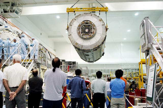 NASA image: KENNEDY SPACE CENTER, FLA. -  In the Space Station Processing Facility, an overhead crane moves the Japanese Experiment Module (JEM) pressure module past other ISS elements to a work stand.  A research laboratory, the pressurized module is the first element of the JEM, named "Kibo" (Hope), to be delivered to KSC.   The National Space Development Agency of Japan (NASDA) developed the laboratory at the Tsukuba Space Center near Tokyo and is Japan's primary contribution to the Station. It will enhance the unique research capabilities of the orbiting complex by providing an additional environment for astronauts to conduct science experiments.  The JEM also includes an exposed facility (platform) for space environment experiments, a robotic manipulator system, and two logistics modules. The various JEM components will be  assembled in space over the course of three Shuttle missions.
