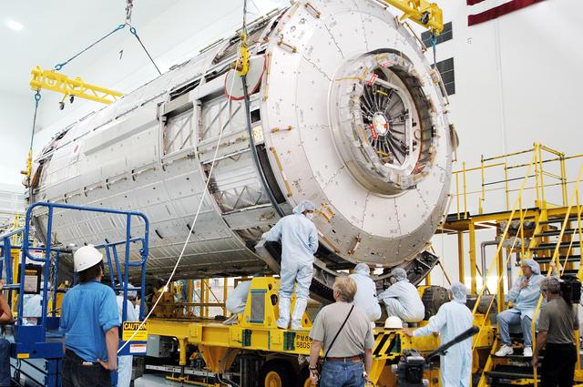 NASA image: KENNEDY SPACE CENTER, FLA. - In the Space Station Processing Facility, the Japanese Experiment Module (JEM) pressure module is lowered onto a work stand.  A research laboratory, the pressurized module is the first element of the JEM, named "Kibo" (Hope), to be delivered to KSC.   The National Space Development Agency of Japan (NASDA) developed the laboratory at the Tsukuba Space Center near Tokyo and is Japan's primary contribution to the Station. It will enhance the unique research capabilities of the orbiting complex by providing an additional environment for astronauts to conduct science experiments.  The JEM also includes an exposed facility (platform) for space environment experiments, a robotic manipulator system, and two logistics modules. The various JEM components will be  assembled in space over the course of three Shuttle missions.