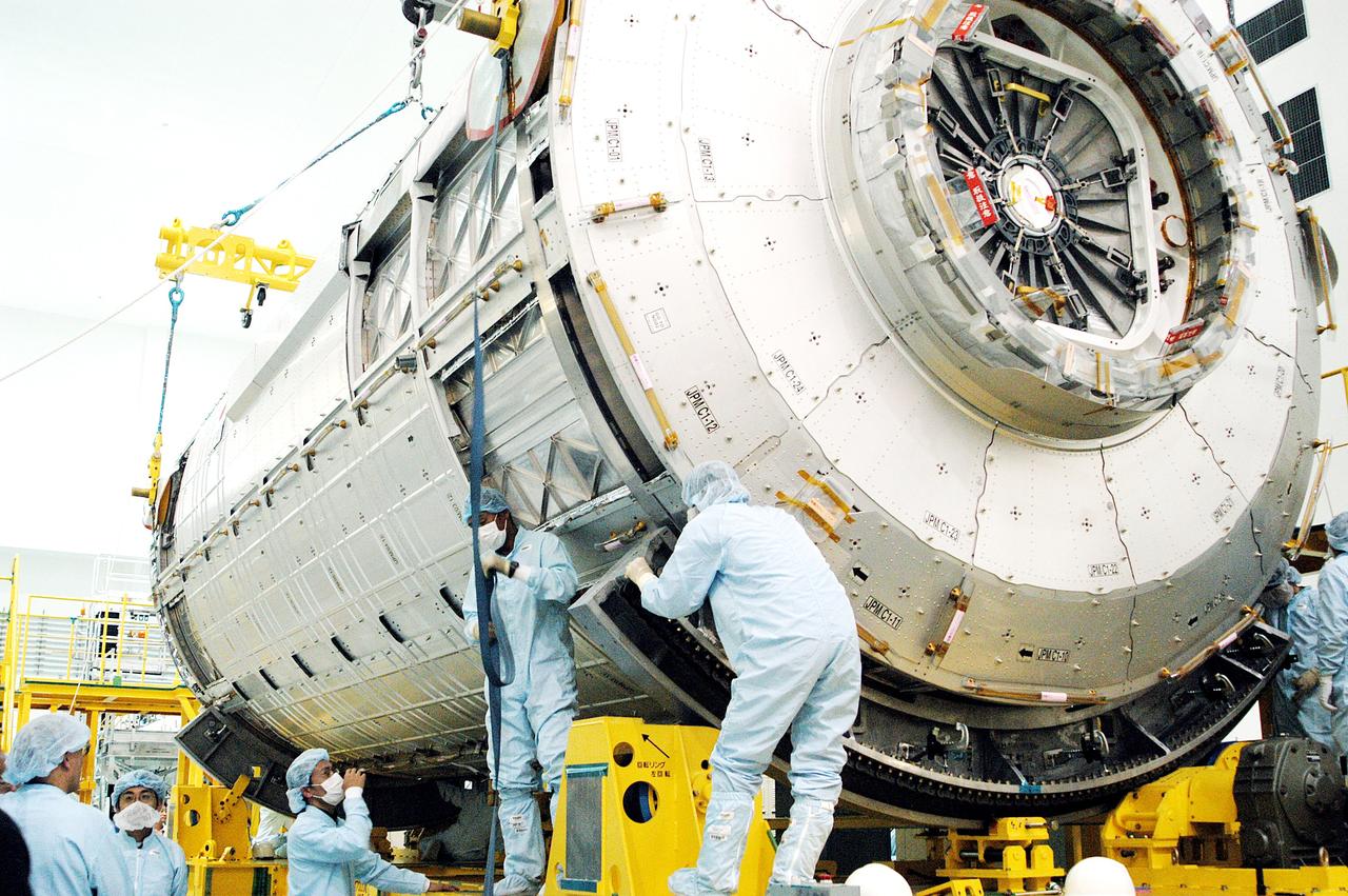 KENNEDY SPACE CENTER, FLA. - In the Space Station Processing Facility, workers check the Japanese Experiment Module (JEM) pressure module on its work stand.  A research laboratory, the pressurized module is the first element of the JEM, named "Kibo" (Hope), to be delivered to KSC.   The National Space Development Agency of Japan (NASDA) developed the laboratory at the Tsukuba Space Center near Tokyo and is Japan's primary contribution to the Station. It will enhance the unique research capabilities of the orbiting complex by providing an additional environment for astronauts to conduct science experiments.  The JEM also includes an exposed facility (platform) for space environment experiments, a robotic manipulator system, and two logistics modules. The various JEM components will be  assembled in space over the course of three Shuttle missions.