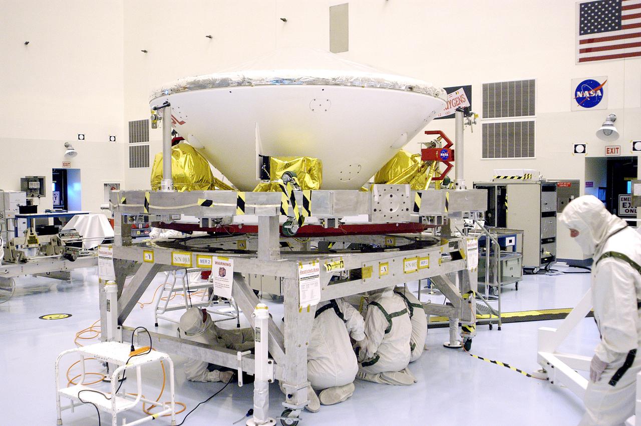 KENNEDY SPACE CENTER, FLA. - Workers in the Payload Hazardous Servicing Facility prepare Mars Exploration Rover 1 (MER-B) to be mated with the third stage of the Delta rocket that will launch it to Mars.  The second of twin rovers being sent to Mars, it is equipped with a robotic arm, a drilling tool, three spectrometers, and four pairs of cameras that allow it to have a human-like, 3D view of the terrain. Each rover could travel as far as 100 meters in one day to act as Mars scientists' eyes and hands, exploring an environment where humans can't yet go.  MER-B is scheduled to launch from Launch Pad 17-B, Cape Canaveral Air Force Station, June 26 at one of two available times,  12:27:31 a.m. EDT or 1:08:45 a.m. EDT.