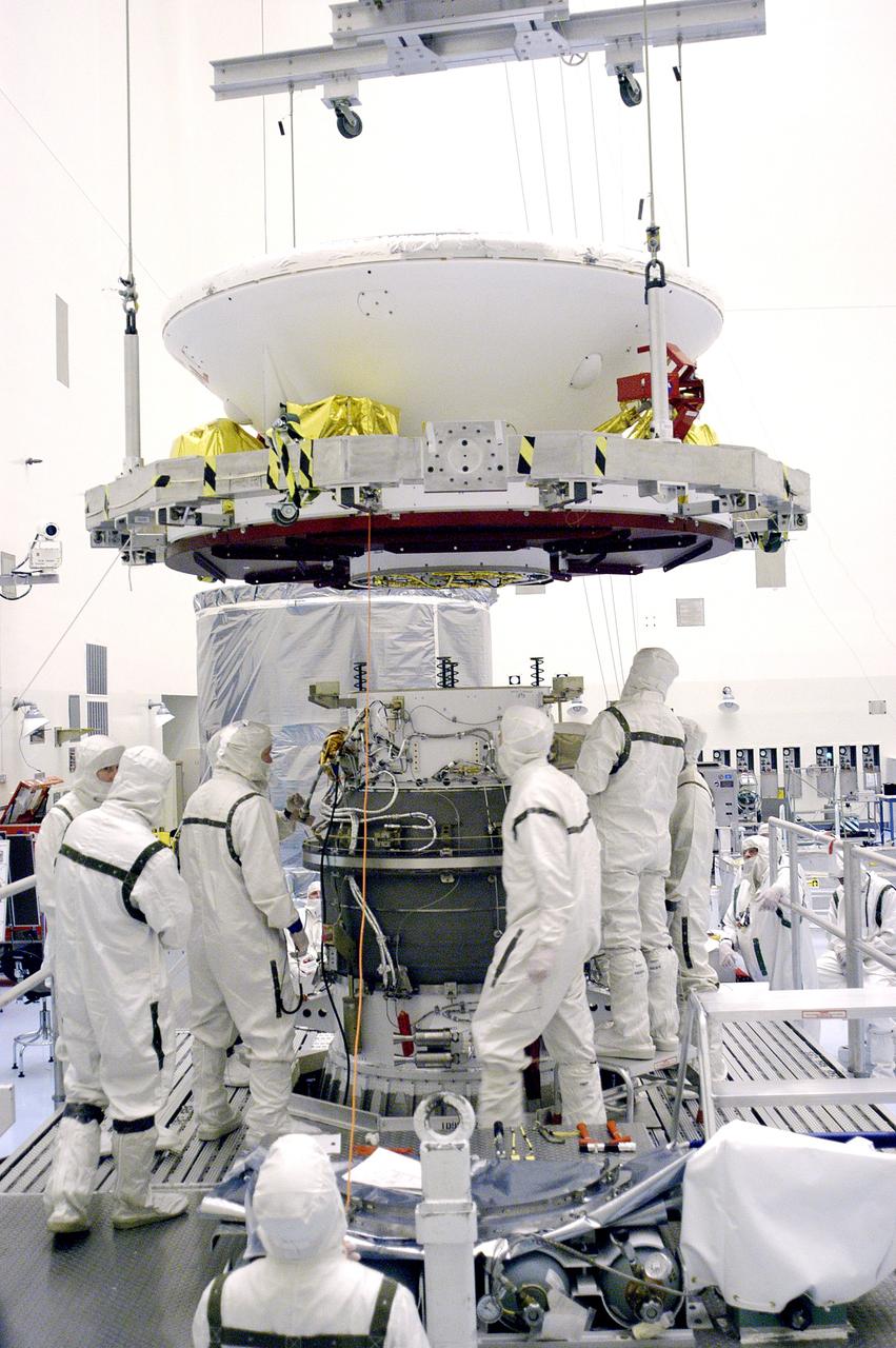 KENNEDY SPACE CENTER, FLA. - In the Payload Hazardous Servicing Facility, an overhead crane lowers Mars Exploration Rover 1 (MER-B) over the third stage of the Delta rocket.  The rover will be mated to the third stage for launch.  The second of twin rovers being sent to Mars, it is equipped with a robotic arm, a drilling tool, three spectrometers, and four pairs of cameras that allow it to have a human-like, 3D view of the terrain. Each rover could travel as far as 100 meters in one day to act as Mars scientists' eyes and hands, exploring an environment where humans can't yet go.  MER-B is scheduled to launch from Launch Pad 17-B, Cape Canaveral Air Force Station, June 26 at one of two available times,  12:27:31 a.m. EDT or 1:08:45 a.m. EDT.
