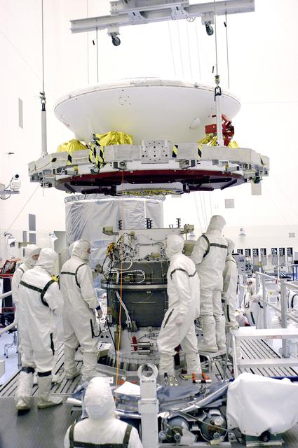 NASA image: KENNEDY SPACE CENTER, FLA. - In the Payload Hazardous Servicing Facility, an overhead crane lowers Mars Exploration Rover 1 (MER-B) over the third stage of the Delta rocket.  The rover will be mated to the third stage for launch.  The second of twin rovers being sent to Mars, it is equipped with a robotic arm, a drilling tool, three spectrometers, and four pairs of cameras that allow it to have a human-like, 3D view of the terrain. Each rover could travel as far as 100 meters in one day to act as Mars scientists' eyes and hands, exploring an environment where humans can't yet go.  MER-B is scheduled to launch from Launch Pad 17-B, Cape Canaveral Air Force Station, June 26 at one of two available times,  12:27:31 a.m. EDT or 1:08:45 a.m. EDT.