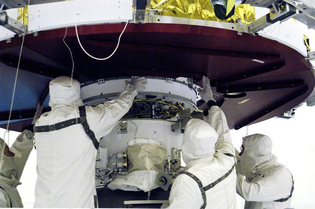 NASA image: KENNEDY SPACE CENTER, FLA. - In the Payload Hazardous Servicing Facility, workers prepare to mate the Mars Exploration Rover 1 (MER-B) above with the third stage of the Delta rocket below.  The second of twin rovers being sent to Mars, it is equipped with a robotic arm, a drilling tool, three spectrometers, and four pairs of cameras that allow it to have a human-like, 3D view of the terrain. Each rover could travel as far as 100 meters in one day to act as Mars scientists' eyes and hands, exploring an environment where humans can't yet go.  MER-B is scheduled to launch from Launch Pad 17-B, Cape Canaveral Air Force Station, June 26 at one of two available times,  12:27:31 a.m. EDT or 1:08:45 a.m. EDT.